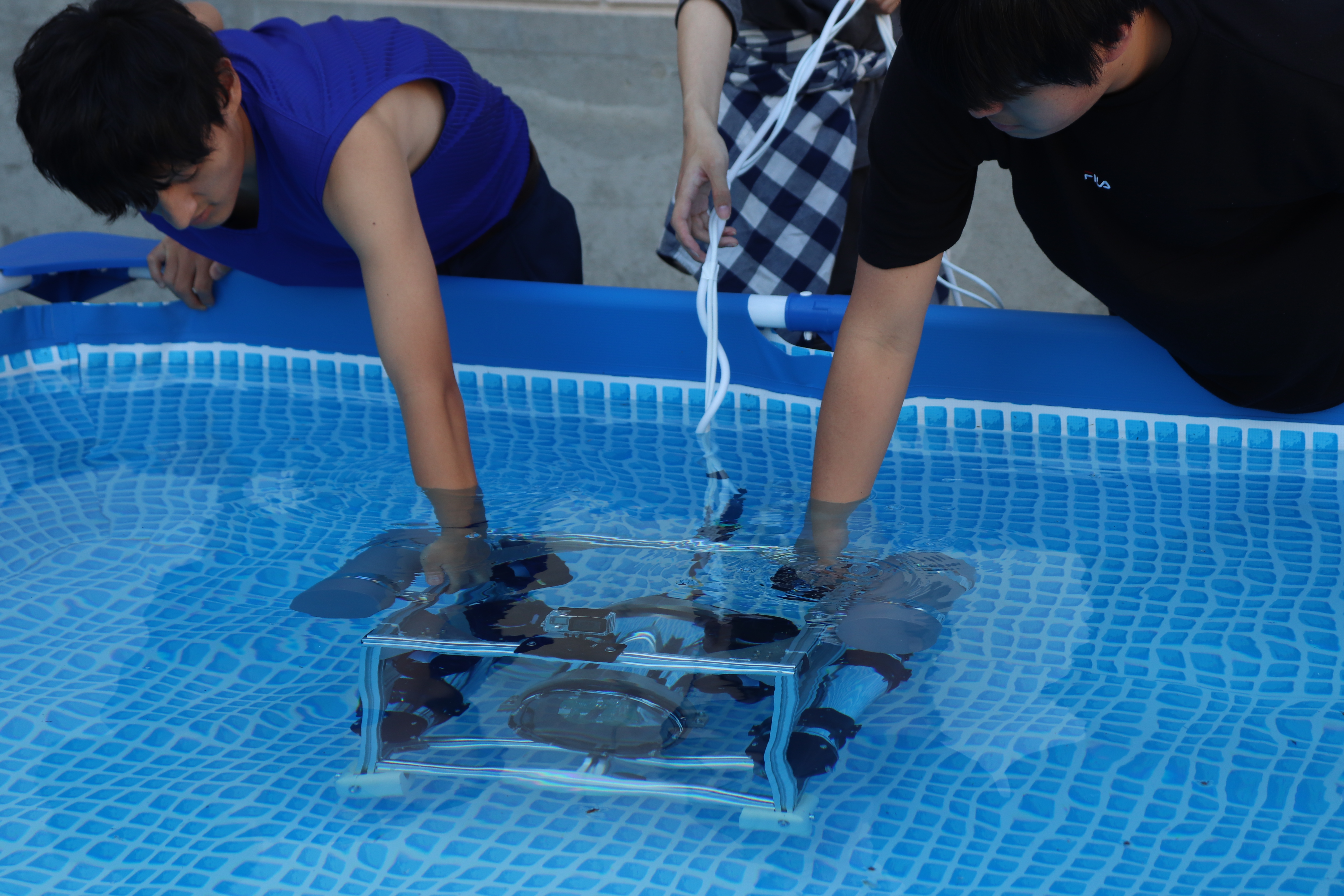 写真：総合制作の作品。海洋ロボットをプールに沈める学生