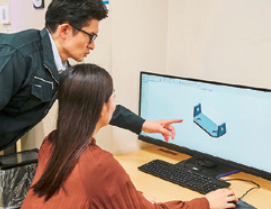 女性と男性がパソコンに向かっている