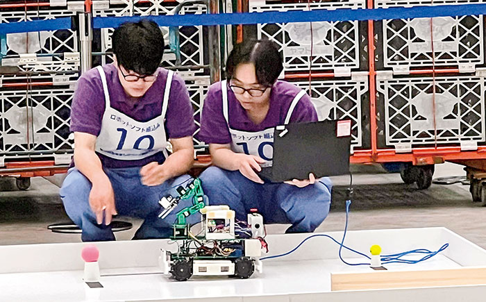 若年者ものづくり競技大会でロボットを操作する学生2名