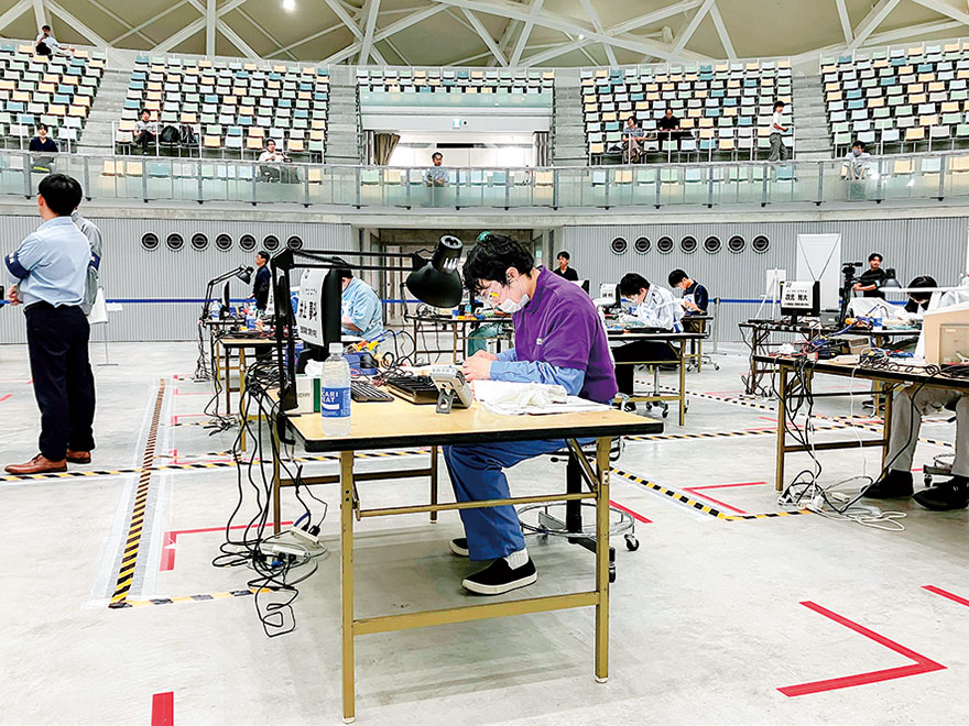 若年者ものづくり競技大会の会場で作業台に向かう出場者たち