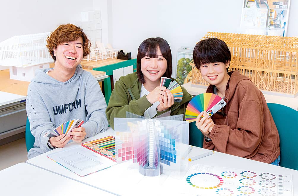 模型を手に語らう建築分野の学生たち