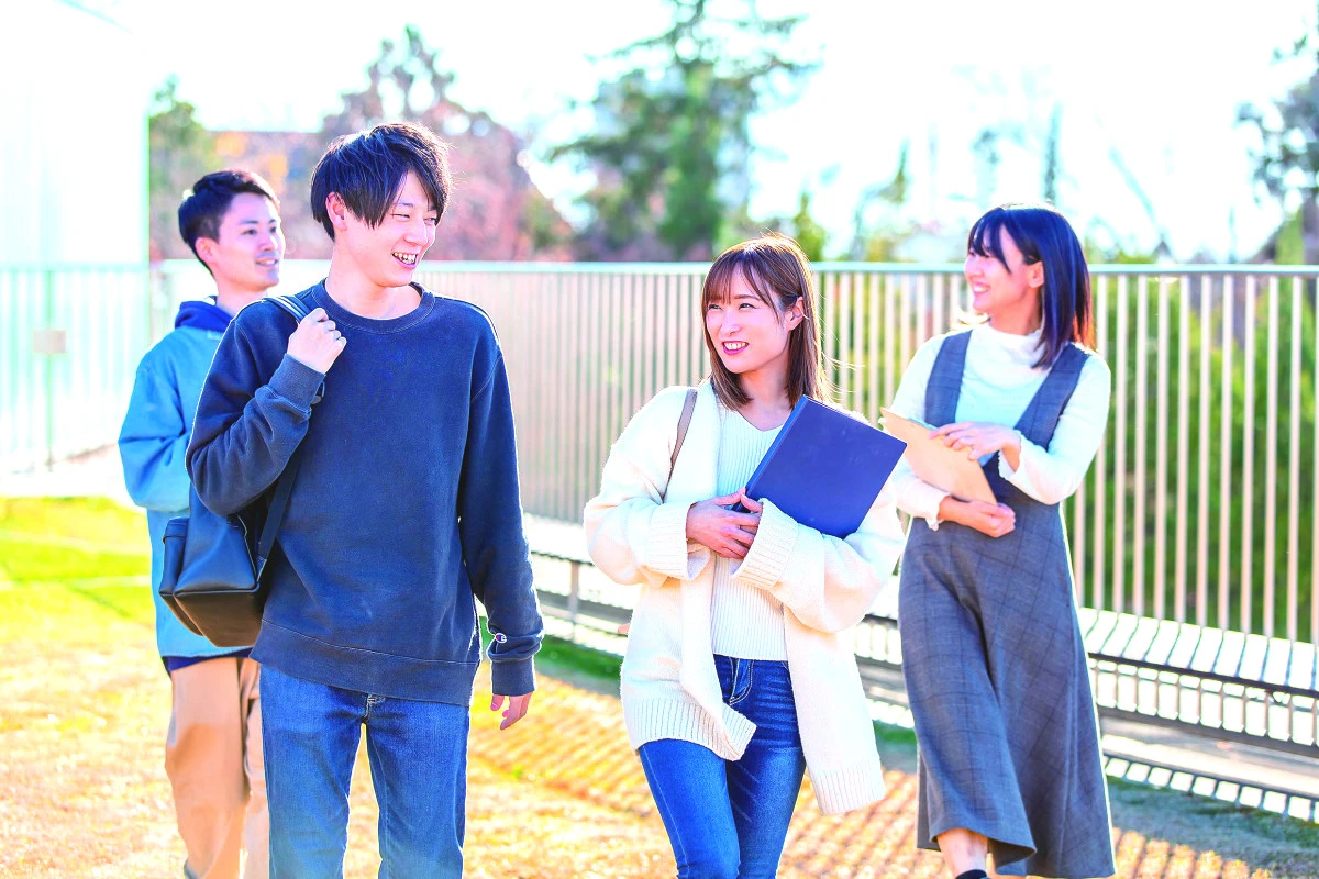 キャンパスを歩く4人の学生
