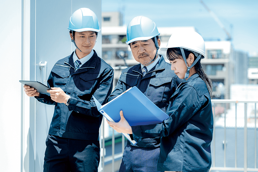 ヘルメット姿で打ち合わせる技術者たち（イメージ）
