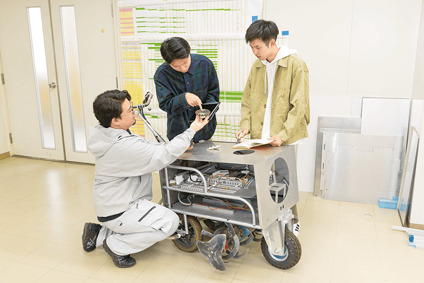 開発したロボットを操作する学生たち