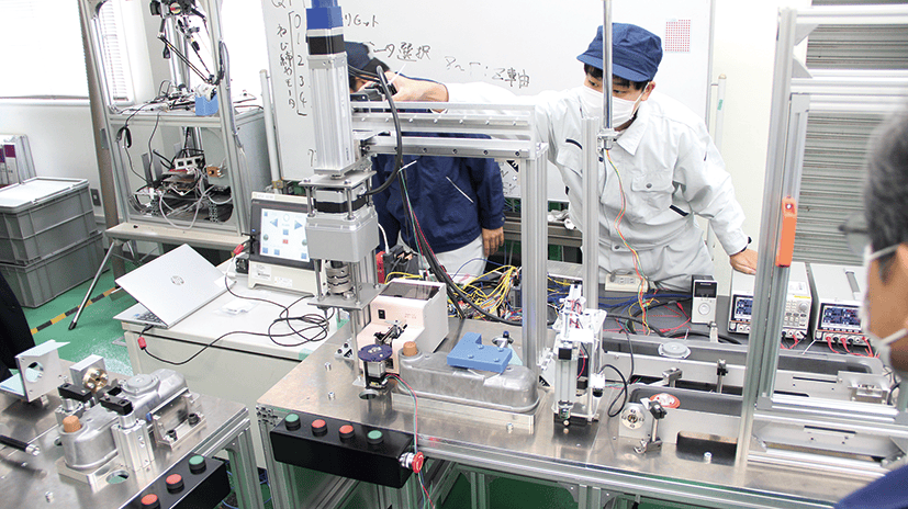 自動化装置の開発に取り組む学生たち