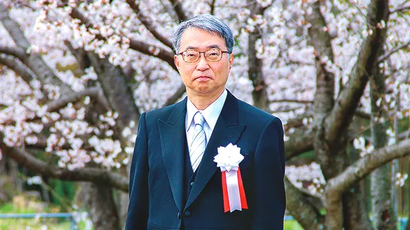 桜を背に立つ校長