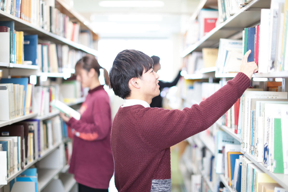 写真：図書館にて本を選ぶ学生の様子