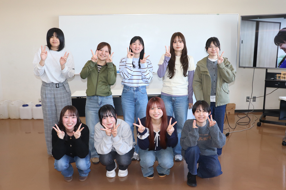 写真：完成した作品を手に笑顔でポーズをとる先輩女子たちの様子